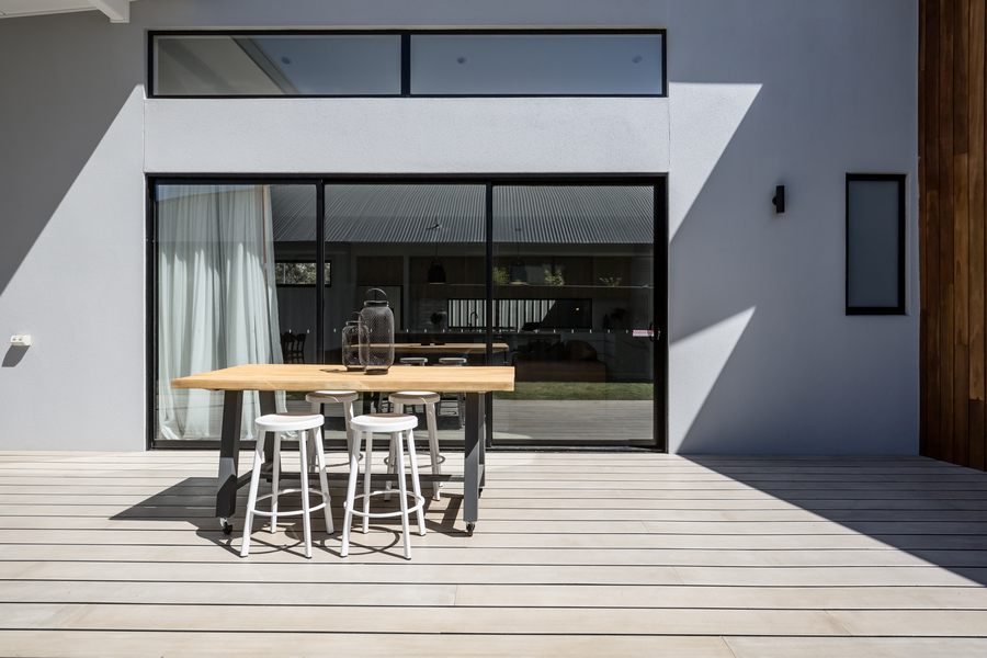 Sunny outdoor entertaining deck with triple glass sliding doors